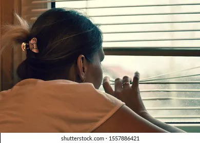 woman-peeps-out-window-through-260nw-1557886421