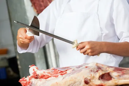 37740392-mujer-carnicero-que-afila-el-cuchillo-en-carnicería
